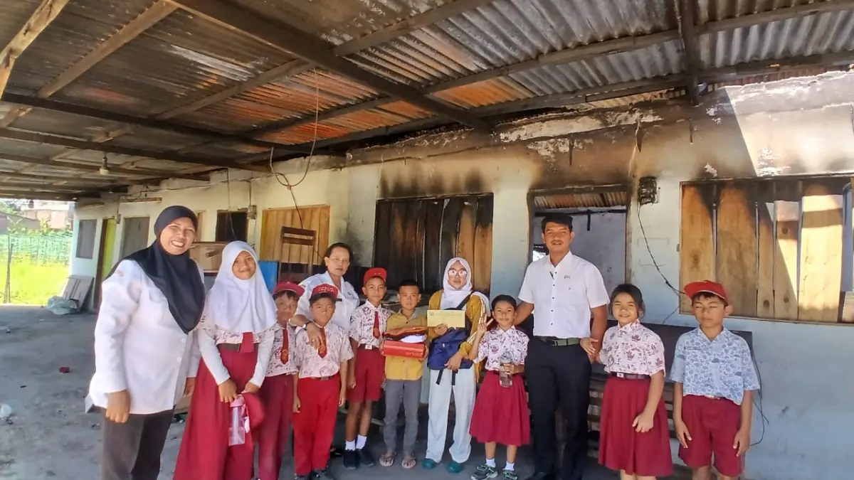 Kepala sekolah, guru, dan siswa SDN 040487 Tiganderket saat menyerahkan bantuan kepada Yoko Prayoga, siswa korban kebakaran di Kabupaten Karo.