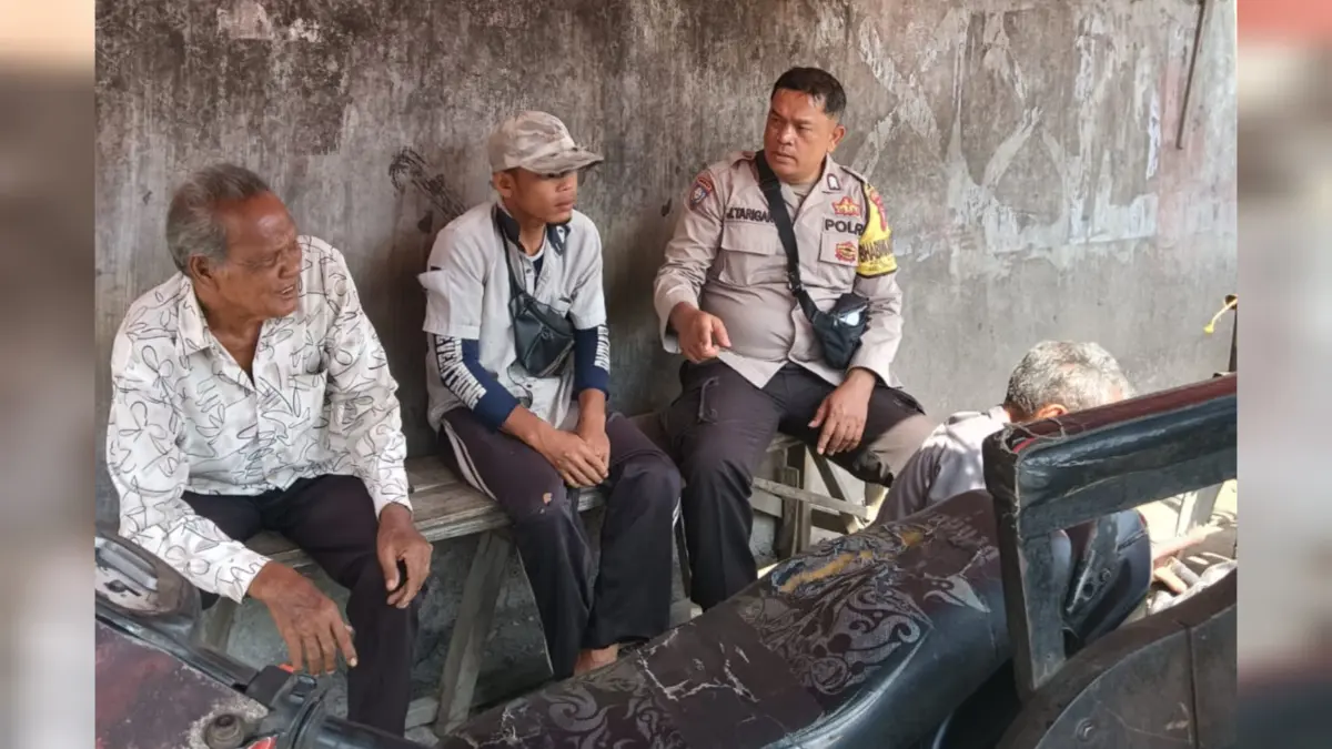 Bripka J. Tarigan Bhabinkamtibmas Polsek Tanjungbalai Utara berdialog dengan warga saat kegiatan sambang di bengkel.