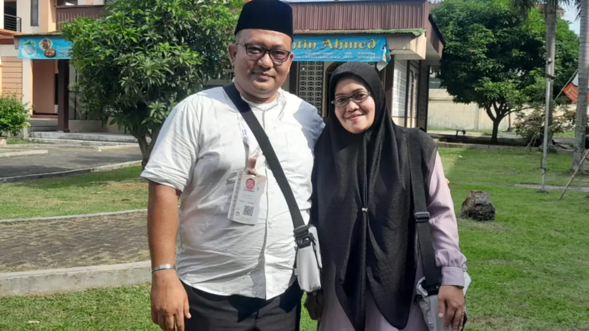 Pasangan suami-istri Ikhsan Lubis dan Nur Leli Nasution, pegawai UPT Samsat Penyabungan Kabupaten Mandailing Natal, saat tiba di Asrama Haji Medan, Senin (27/4/2026), siap diberangkatkan ke Tanah Suci dalam Kloter 6.