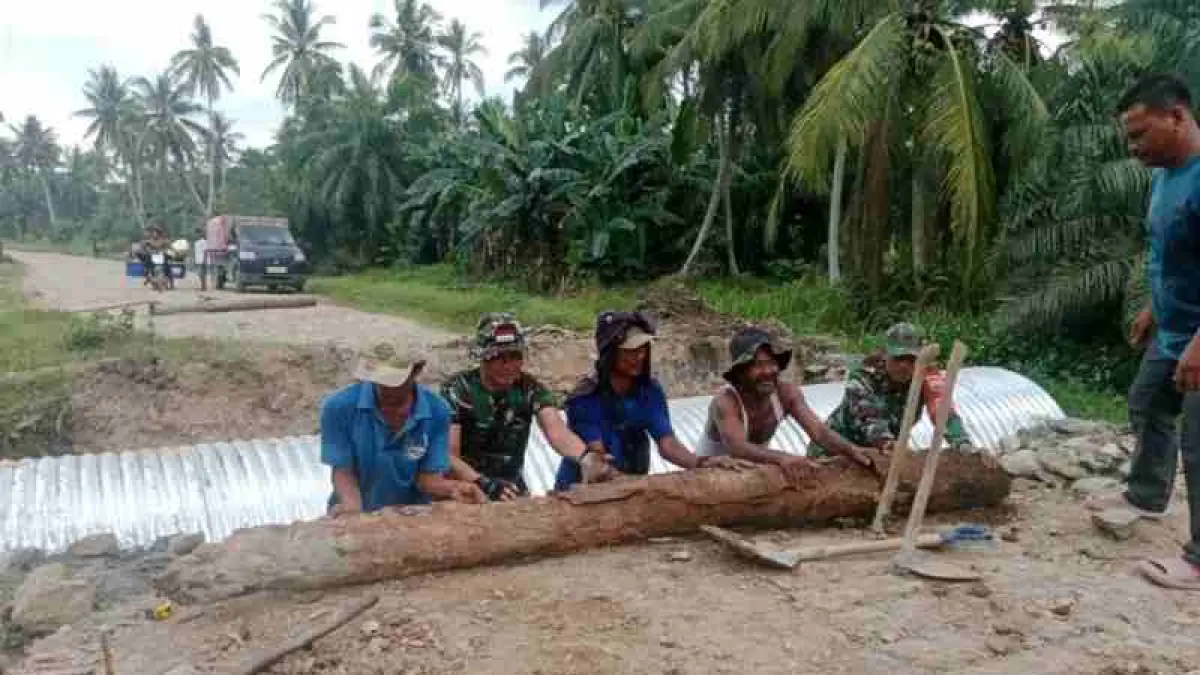 Personel Koramil 02/TL bersama warga bergotong royong menyelesaikan pembangunan Jembatan Aramco di Kualuh Hilir, Labuhanbatu Utara.