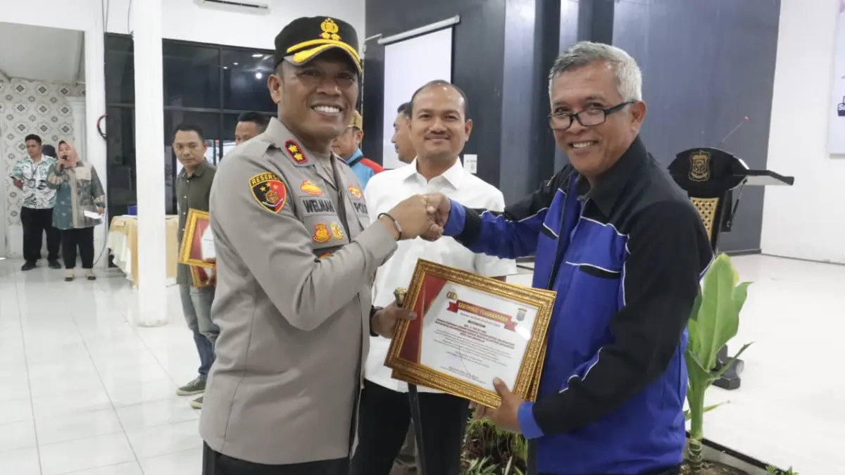 Kapolres Tanjungbalai AKBP Welman Feri bersama Forkopimda menyerahkan penghargaan kepada perwakilan buruh pada peringatan May Day 2026.