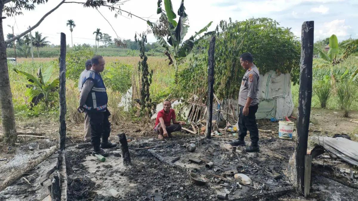Petugas kepolisian dari Polsek Siantar Martoba melakukan pendataan di lokasi rumah yang terbakar di areal kebun sawit, Kelurahan Gurilla, Kota Pematangsiantar.