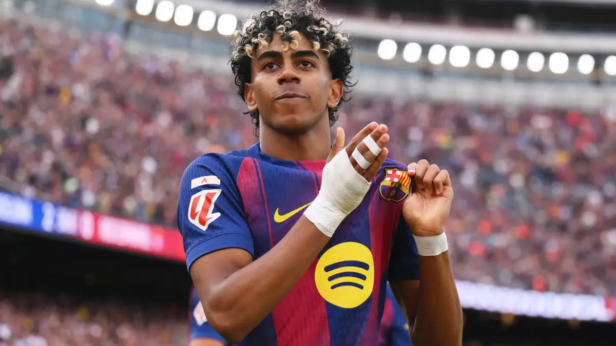 Lamine Yamal merayakan parade juara Liga Spanyol bersama Barcelona sambil mengenakan jersey sindiran untuk Real Madrid.