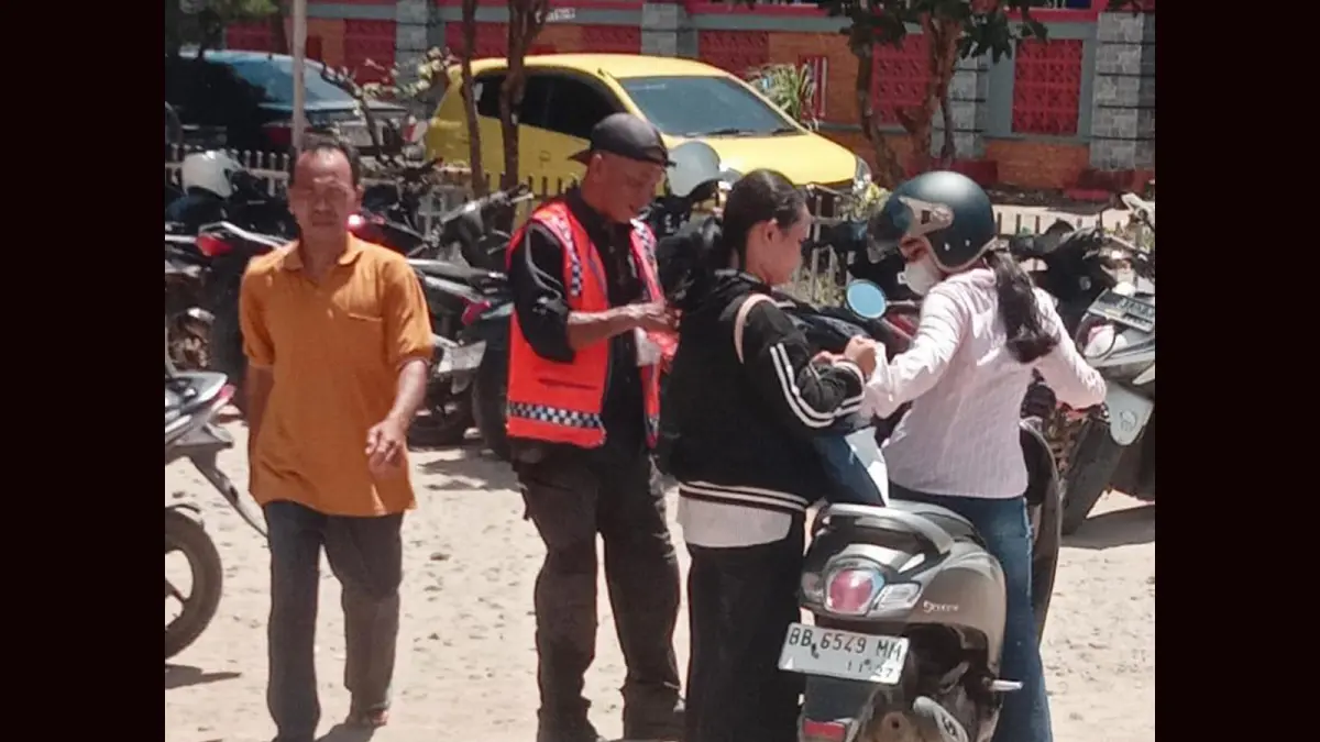 Petugas parkir mengutip retribusi dari warga di halaman Kantor Disdukcapil Tapanuli Tengah yang kini menuai sorotan publik.
