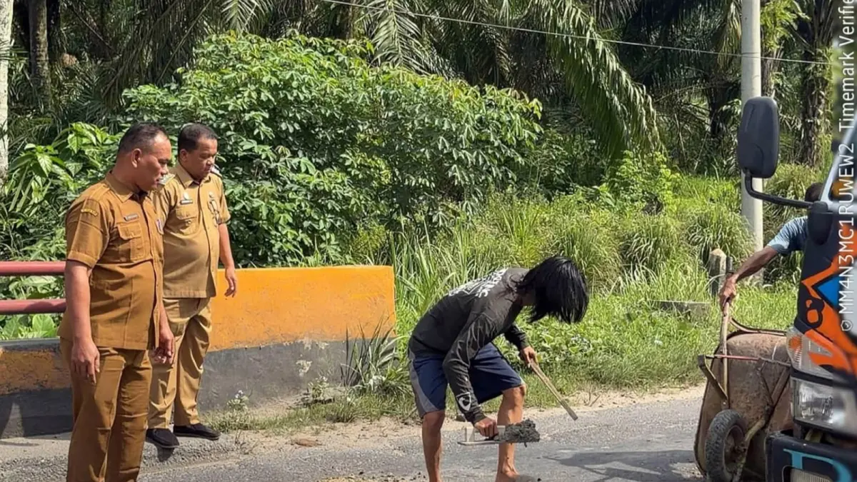 Camat Na IX-X Sukur Pasaribu bersama pegawai kecamatan melakukan gotong royong menambal jalan berlubang di Jalinsum Aek Merah, Kabupaten Labuhanbatu Utara, Senin (18/5/2026).