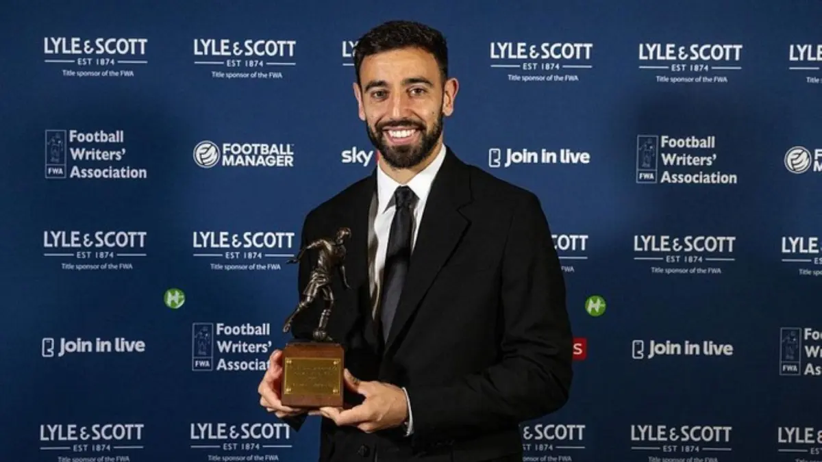 Bruno Fernandes menunjukkan trofi pemain terbaik Liga Inggris versi Football Writers