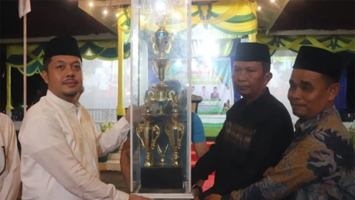Bupati Paluta H.Reski Basyah Harahap menyerahkan piala bergilir kepada Camat Dolok Sigompulon.