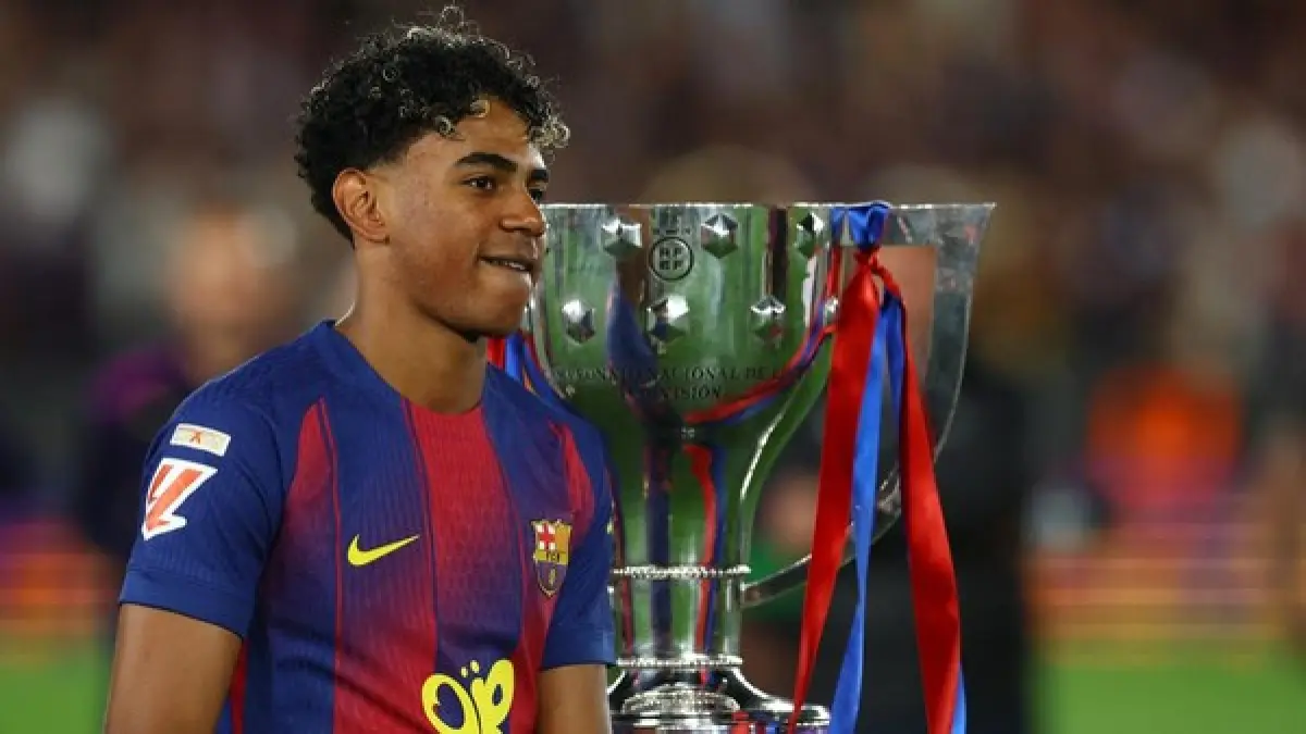 Lamine Yamal berpose dengan trofi penghargaan Pemain Terbaik LaLiga 2025/26 setelah sukses membawa Barcelona mempertahankan gelar juara liga musim ini.