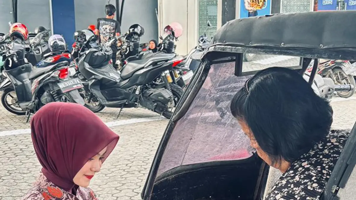 Petugas Teller BRI KC Padangsidimpuan memberi pelayanan langsung kepada Ibu lansia yang berada di dalam becak.