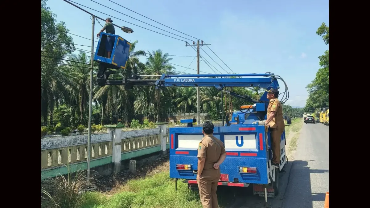 Kepala Desa Gunung Melayu, Sahran Tanjung, memantau pemasangan lampu penerangan jalan di kawasan Simpang Tegal Lego dan Dusun IV A Palia, Kecamatan Kualuh Selatan, Labuhanbatu Utara, Selasa (9/6/2026).