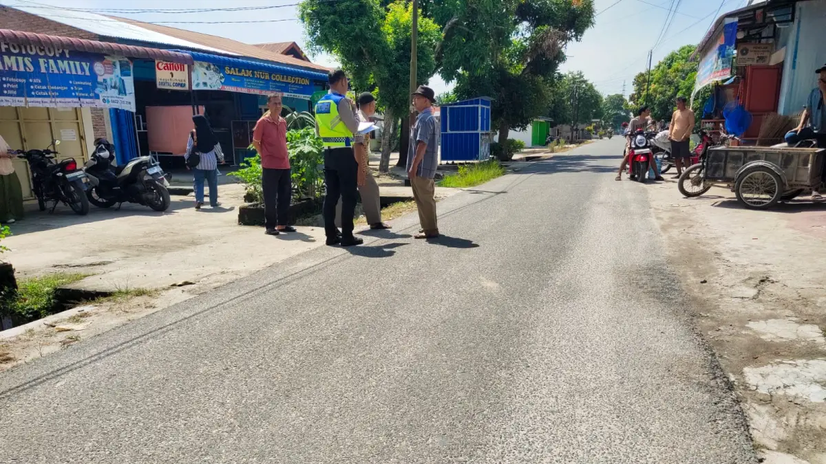 Petugas Satlantas Polres Asahan melakukan olah tempat kejadian perkara (TKP) kecelakaan lalu lintas yang melibatkan seorang lansia dan sepeda motor yang dikendarai remaja di wilayah Kisaran, Kabupaten Asahan. 