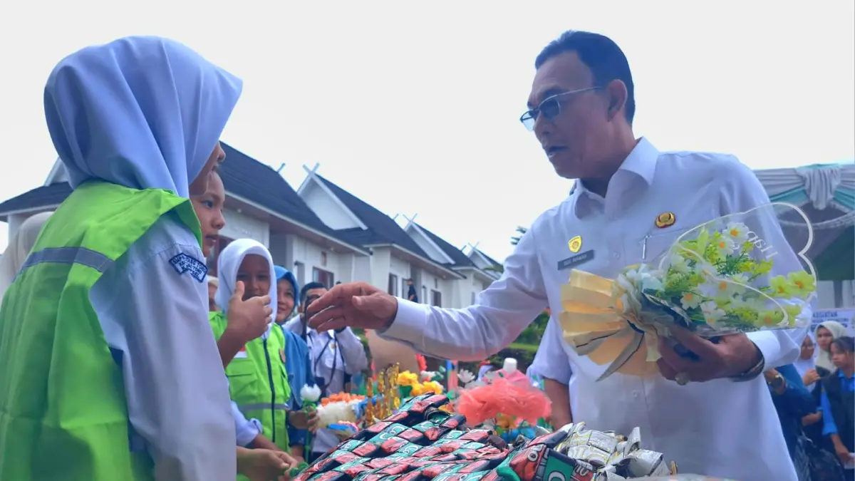 Gus Irawan menerima buah tangan olahan sampah plastik oleh siswa-siswi sekolah adiwiyata di Tapsel, Rabu (17/6/2026) dalam peringatan hari lingkungan hidup sedunia 2026. (Samman/MetroDaily)