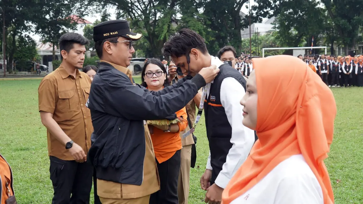 Wali Kota Medan Rico Tri Putra Bayu Waas menyematkan tanda petugas saat Pencanangan dan Apel Siaga Sensus Ekonomi 2026 di Lapangan Balai Desa, Kecamatan Medan Helvetia, Senin (15/6/2026). 