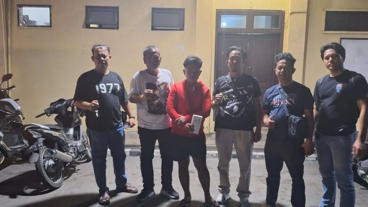  Gunawan Purba (jaket merah) diamankan polisi setelah diduga mencuri telepon seluler milik seorang sopir truk dan membobol rekening korban melalui layanan mobile banking di Kabupaten Simalungun. 