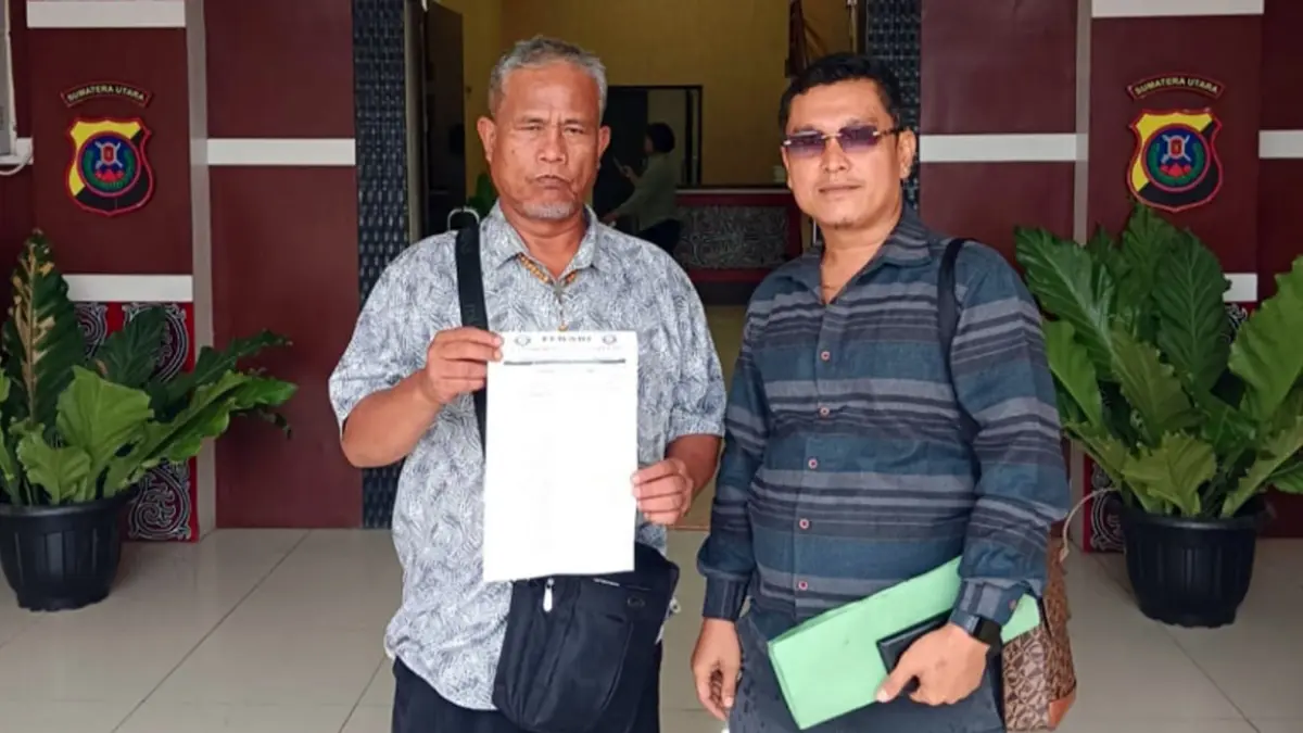 Edward Halomoan Harianja didampingi kuasa hukumnya, Gokma Pandiangan, usai melaporkan pemilik akun Facebook Serli Napitu ke Polres Samosir atas dugaan pencemaran nama baik melalui media sosial.