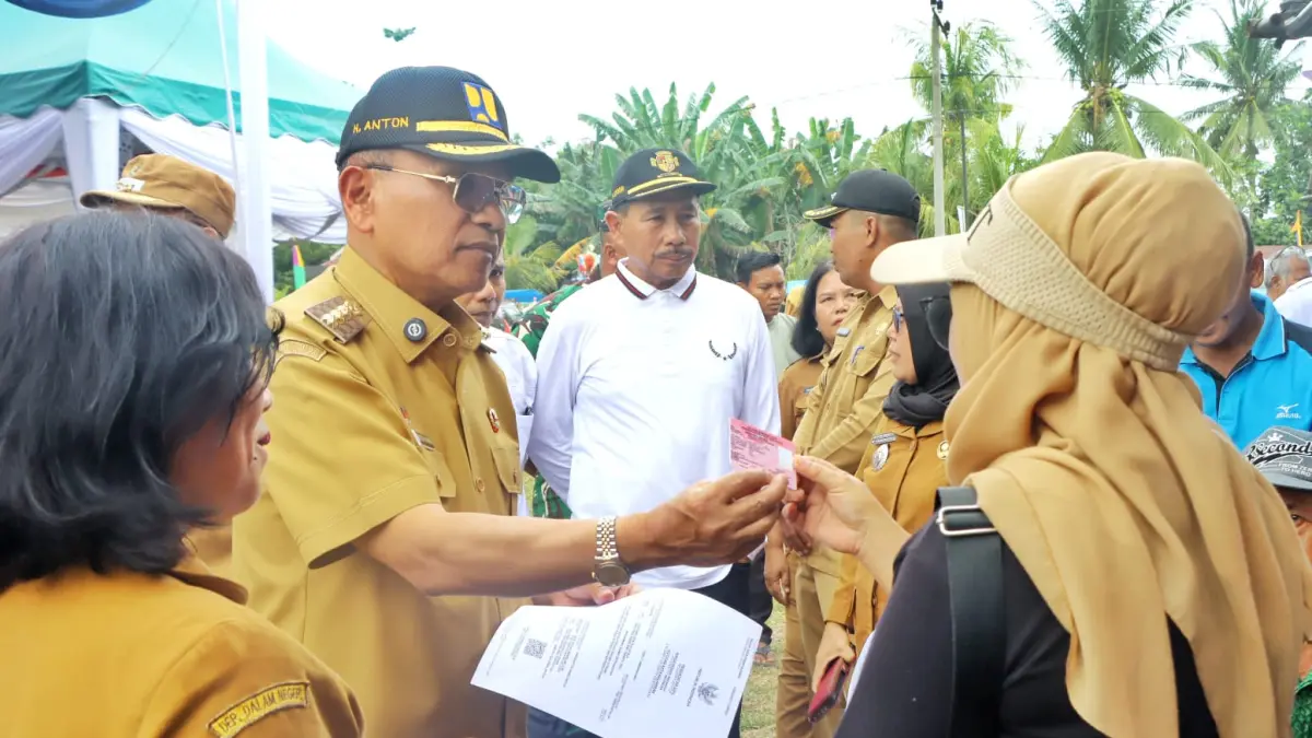 Bupati Simalungun H. Anton Achmad Saragih menyerahkan KTP kepada warga saat kegiatan pelayanan terpadu di Nagori Bandar Rejo, Kecamatan Bandar Masilam.