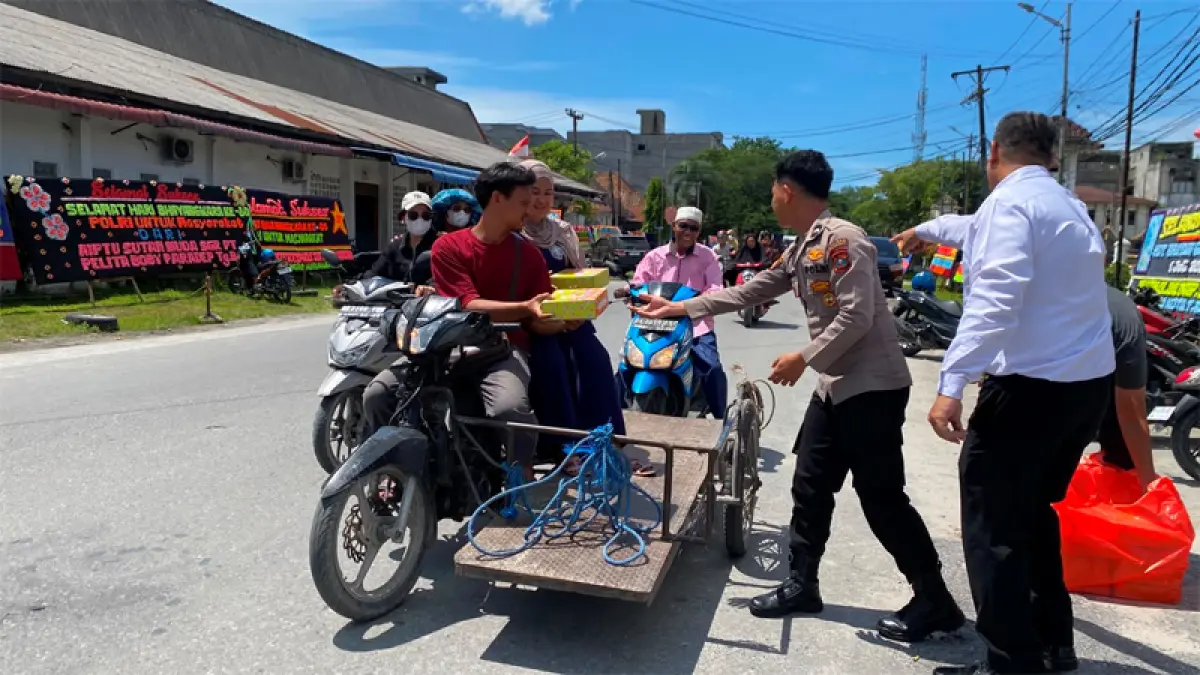 Personil Polres Tanjungbalai membagikan nasi kotak kepada abang becak dan pengendara yang melintas.