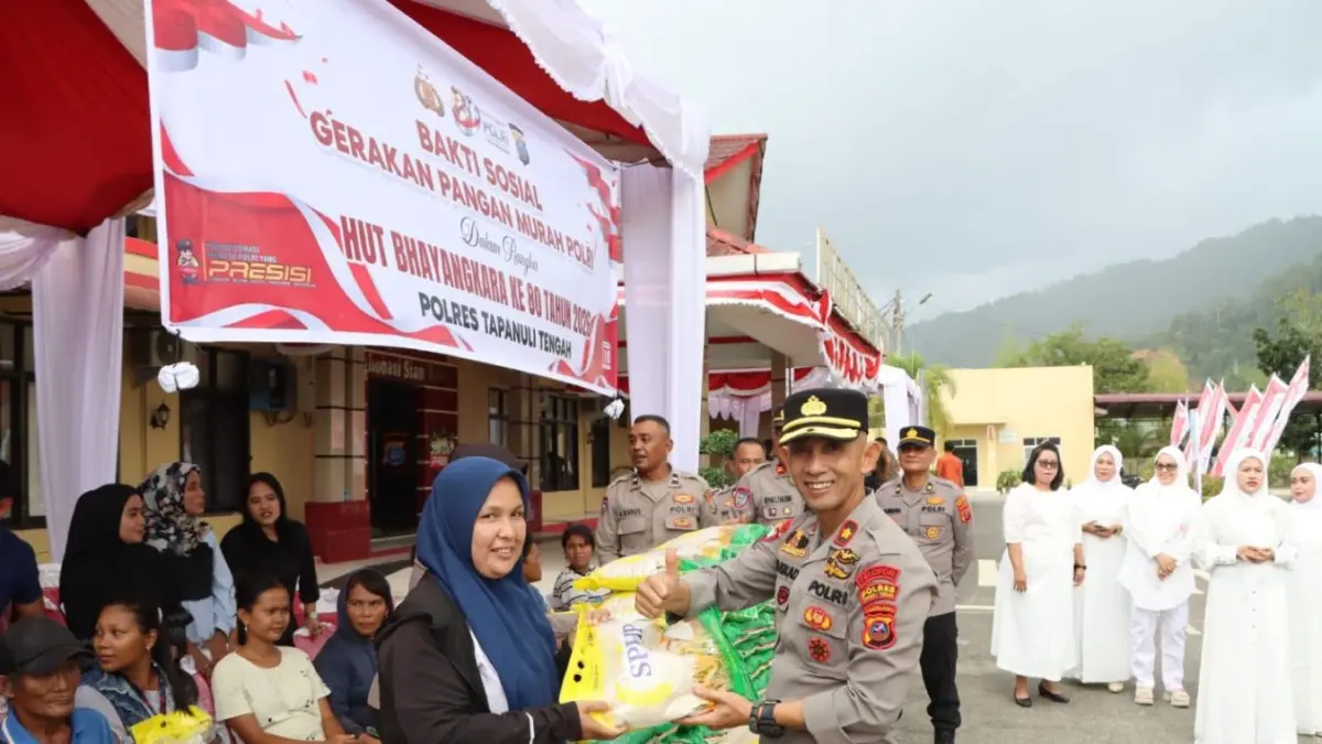 Kapolres Tapanuli Tengah AKBP Muhammad Alan Haikel menyerahkan bantuan beras kepada warga dalam Gerakan Pangan Murah Polri memperingati Hari Bhayangkara ke-80.