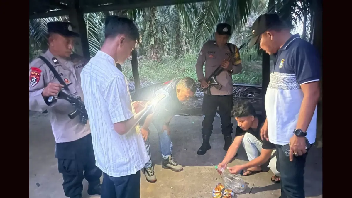 Personel Polsek Torgamba menunjukkan barang bukti berupa bong, plastik klip, mancis, dan pipet yang ditemukan saat menggerebek lokasi diduga sarang narkoba di Afdeling C Desa Aek Raso, Labuhanbatu Selatan. 