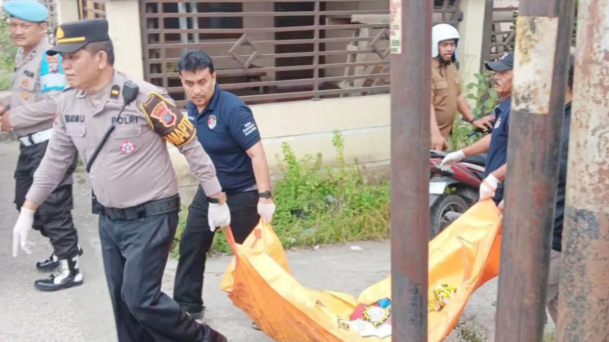 Petugas kepolisian mengevakuasi jenazah Rona Rio Sitorus (24), warga Kabupaten Simalungun, yang ditemukan meninggal dunia di bekas warung nasi depan BRI Simpang Medan, Kota Tebing Tinggi, Selasa (14/7). 