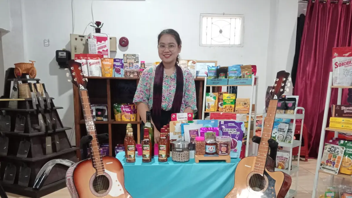 Penjaga Paviliun Pemkab Tapanuli Utara menunjukkan gitar Sipoholon karya perajin lokal Petrus Hutagalung yang dipamerkan pada PRSU ke-50 di Medan. Gitar buatan tangan tersebut kini telah dipasarkan secara nasional.