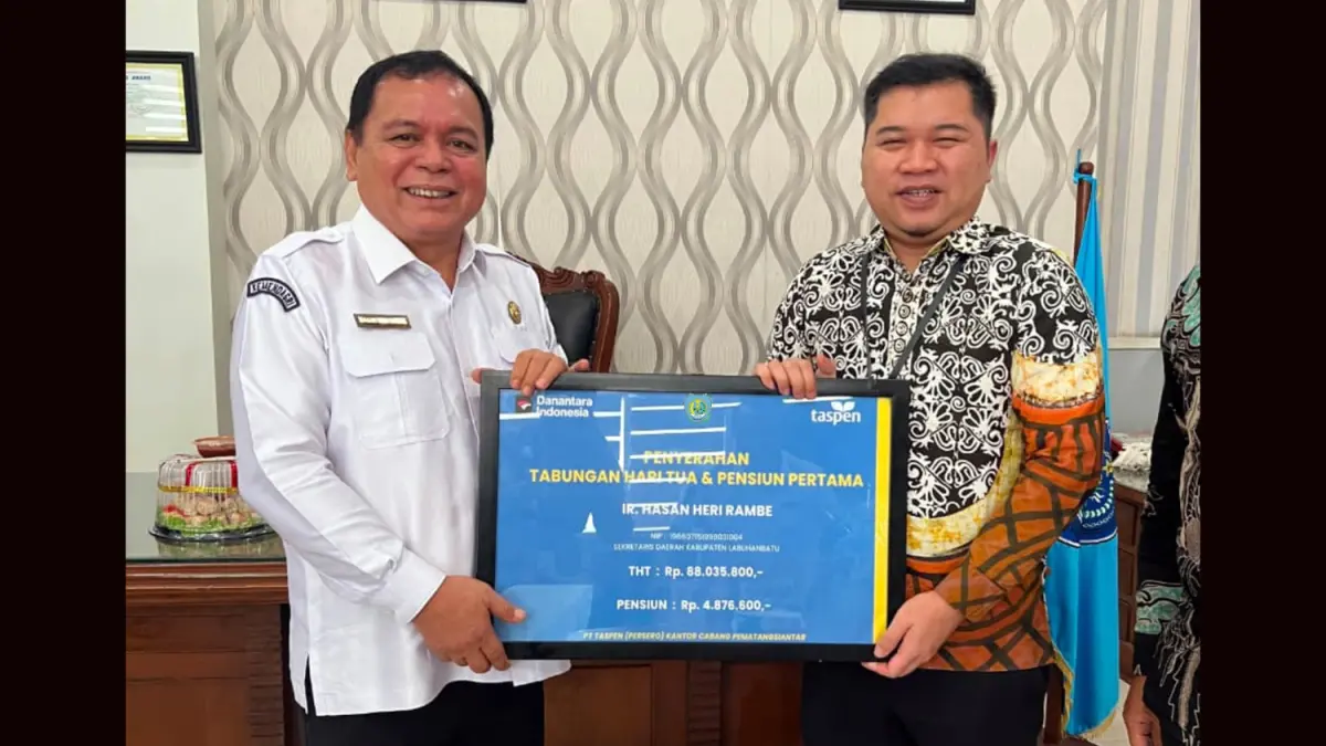 Branch Manager TASPEN Pematangsiantar Maulana Setiawan menyerahkan simbolis klaim Tabungan Hari Tua (THT) dan pensiun pertama kepada Sekda Labuhanbatu Ir. Hasan Heri Rambe.