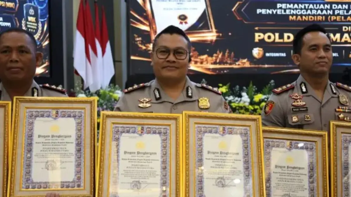 Kapolres Sibolga AKBP Eddy Inganta menunjukkan dua piagam penghargaan Kapolri yang diraih Polres Sibolga atas predikat Wilayah Bebas dari Korupsi (WBK) dan Pelayanan Prima Tahun 2025.