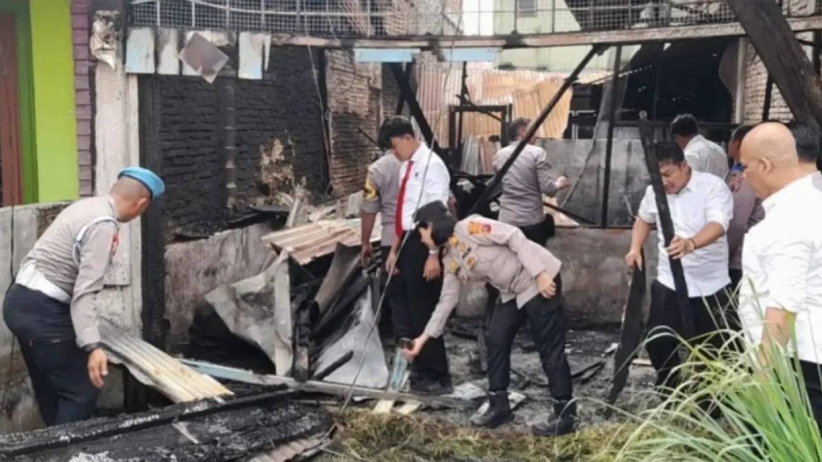 Personel Polsek Kualuh Hulu dipimpin Kapolsek membersihkan puing puing kebakaran rumah milik warga.