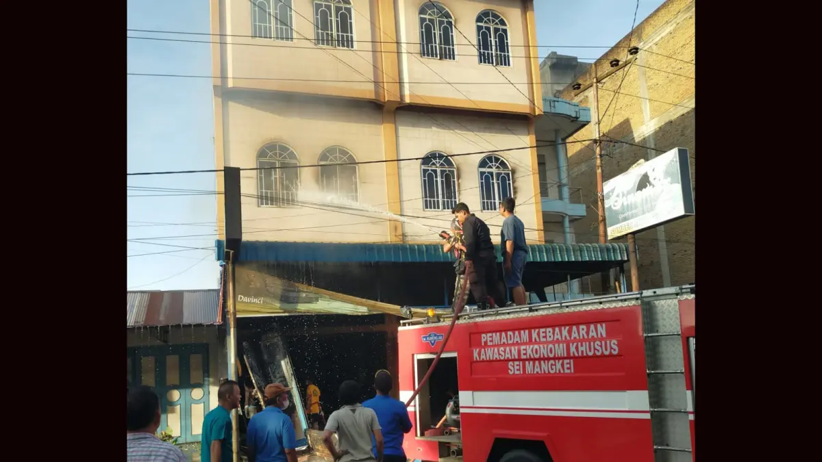 Petugas pemadam kebakaran berupaya memadamkan kobaran api yang melalap dua toko perabot dan elektronik di Jalan Sisingamangaraja, Kelurahan Perdagangan I, Kecamatan Bandar, Kabupaten Simalungun. 