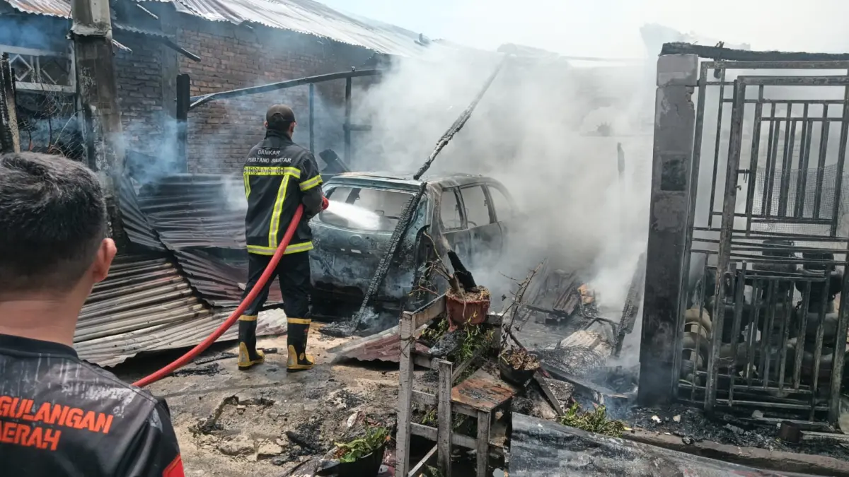 Petugas pemadam kebakaran memadamkan api yang menghanguskan dua rumah dan satu mobil di Jalan Sumber Jaya 1, Kelurahan Sumber Jaya, Kecamatan Siantar Martoba, Pematangsiantar