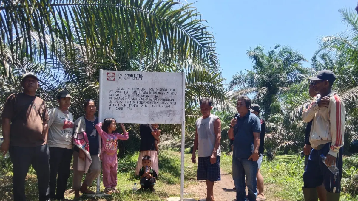 Sejumlah petani sawit yang kebunnya berbatasan dengan areal PT SMART Tbk Kebun Adipati, Desa Belungkut, Kecamatan Marbau, Labura, berada di sekitar plang. 