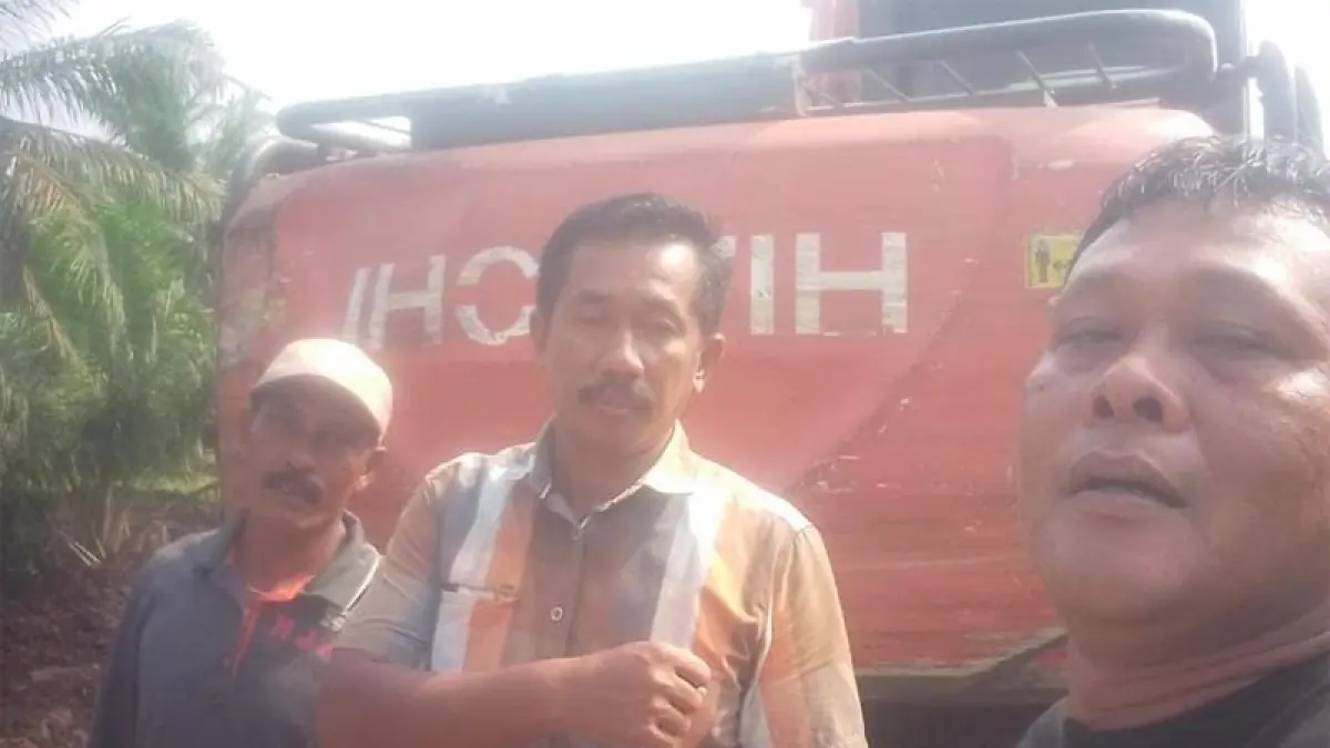 Parumum Hasibuan berfoto dengan pemilik excavator di lokasi areal kebun PT SMART Tbk Kebun Adipati di Desa Belungkut, Kecamatan Marbau, Labura.
