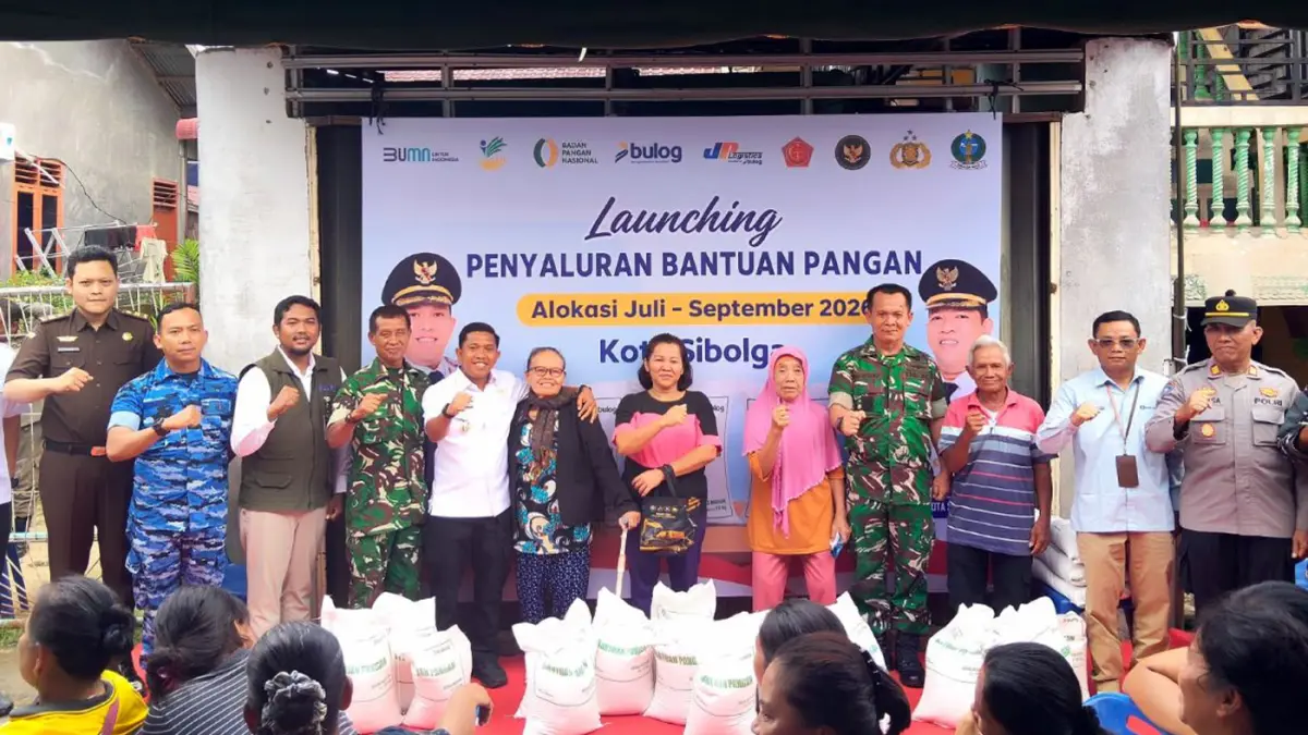 Wali Kota Sibolga Akhmad Syukri Penarik bersama Kepala Bulog Sibolga Muhamad Bagus Aminullah dan Forkopimda berfoto dengan warga penerima bantuan pangan. (Darwis Halawa/MetroDaily)
