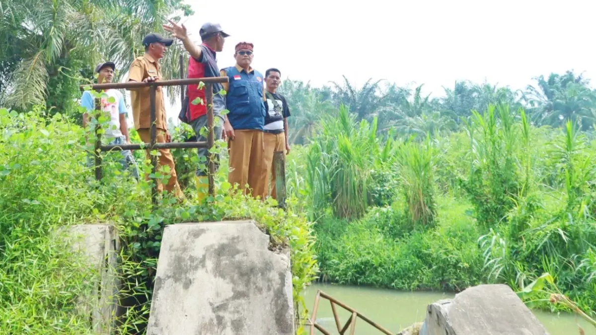 Kepala BPBD Simalungun Budiman Silalahi meninjau kondisi bendungan yang rusak akibat banjir di Nagori Sei Merbau, Kecamatan Ujung Padang. 