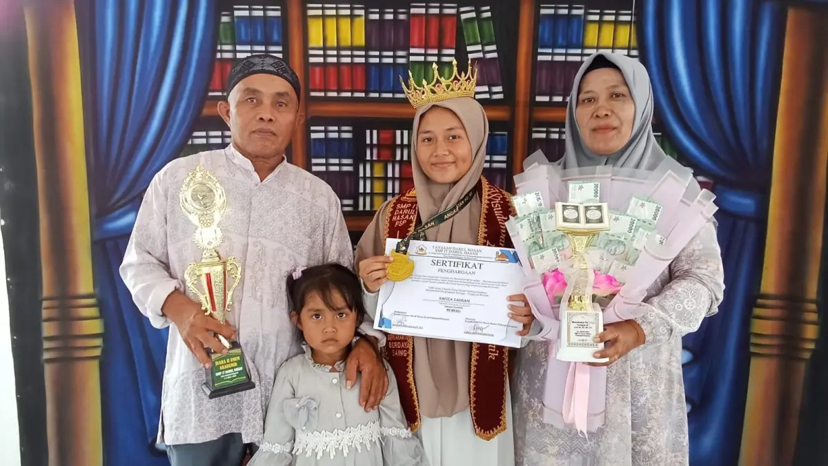 Nafiza bersama orang tua menerima piagam dan trofi penghargaan saat kelulusan di SMP IT Darul Hasan Kota Padangsidimpuan. (Ist)