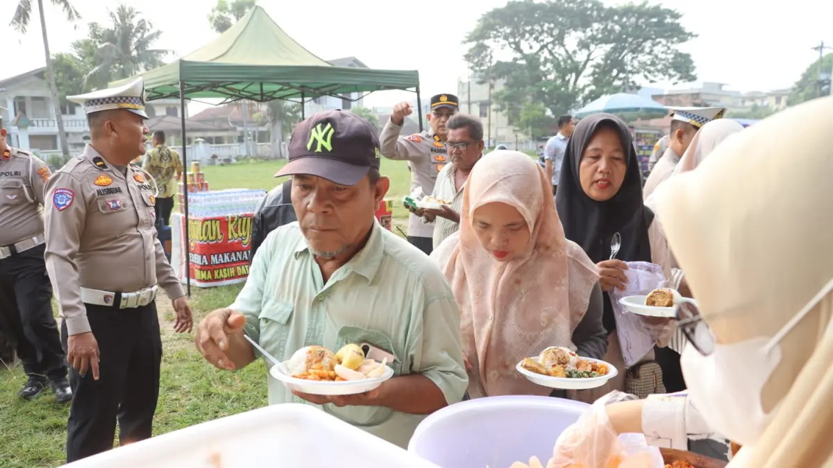 Sejumlah warga saat menikmati makanan gratis dari Polres Labuhanbatu