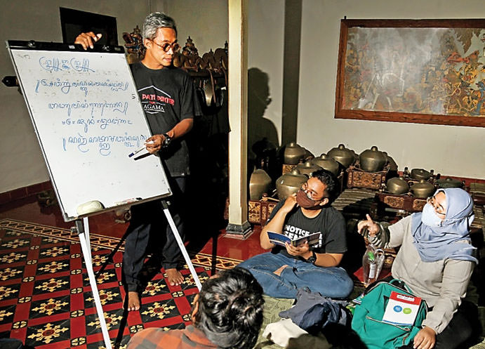 (MUHAMAD ALI/JAWA POS) PELESTARI BUDAYA: Pakdjo (kiri) berdiskusi dengan kawan-kawannya di komunitas Banyu Mangsi di Oman Pitoe, Jogjakarta, Jumat lalu (4/6).