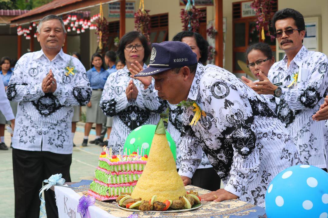 Foto: New Tapanuli/Sunday Sihotang Kepala SMA Negeri 1 Parlilitan, Panutur Simorangkir, SPd meniup lilin pada acara ulang tahun Hari Guru sebelum pandemi Covid-19.