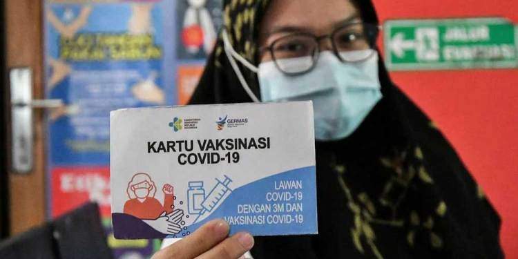 Seorang warga menunjukkan kartu vaksin sebagai bukti telah divaksin Covid-19. Kartu ini menjadi salah satu syarat bagi masyarakat yang ingin menumpang kereta api.