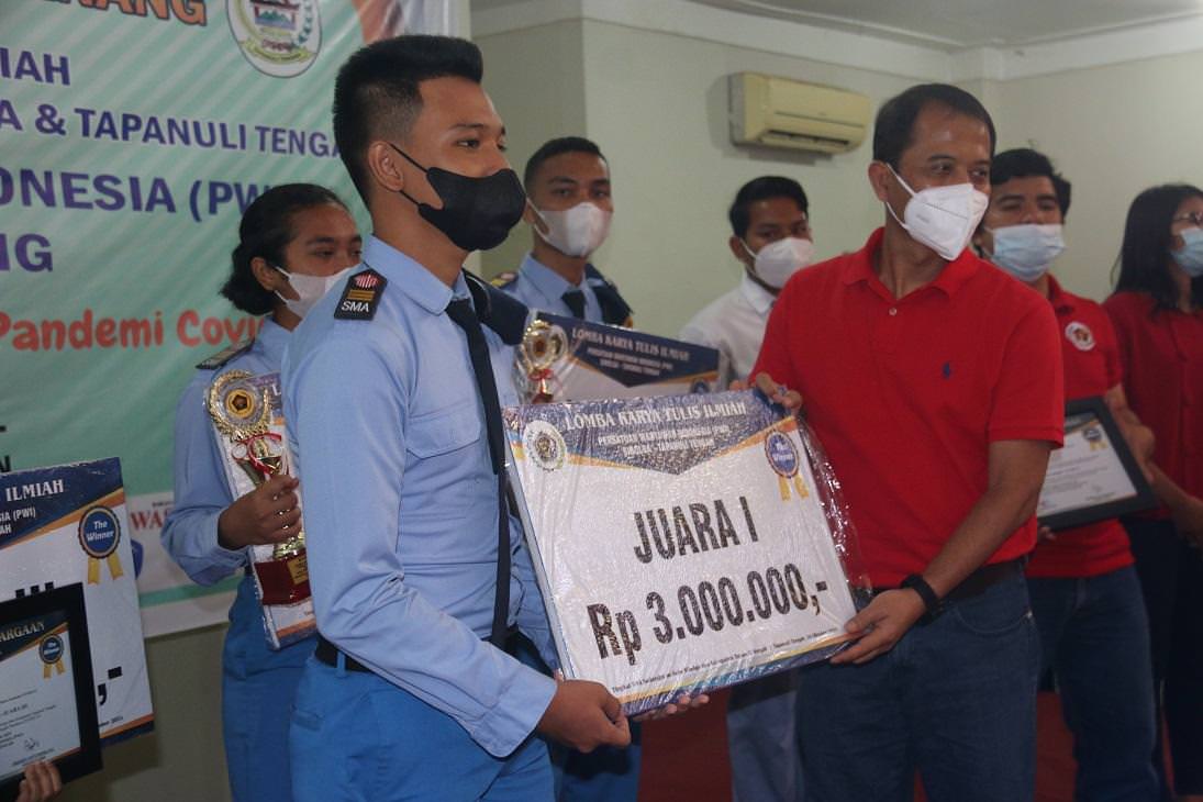 Foto: Ridwan/New Tapanuli Kepala Kantor Perwakilan BI Sibolga Aswin Kosotali saat menyerahkan hadiah kepada juara I Lomba KTI yang digelar Persatuan Wartawan Indonesia (PWI) Sibolga-Tapteng, Sabtu (16/10).