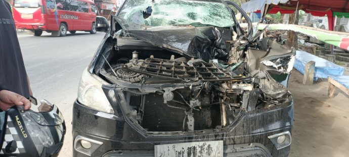 Foto: Vino/Metro Asahan Mobil Toyota Innova yang ringsek setelah menabrak bagian belakang truk di jalan Sudirman, Tanjungbalai.