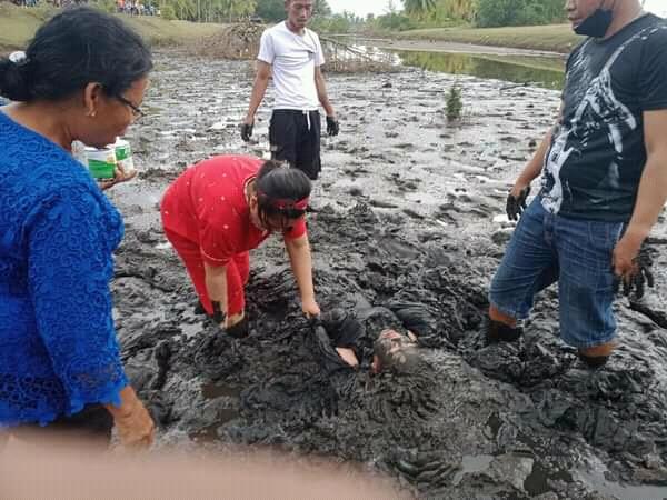 Foto: Istimewa Warga melakukan upaya penyelamatan dengan cara merendam tubuh Tika Situmeang dalam lumpur.
