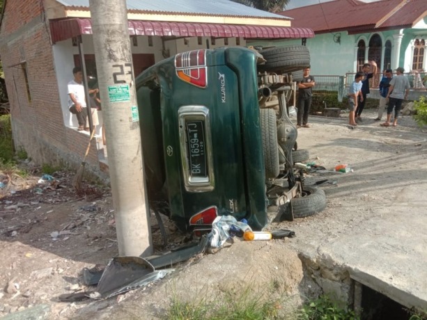 Mobil Kijang yang terbalik di jalan Pematangsiantar-Parapat, Minggu (19/6/2022).