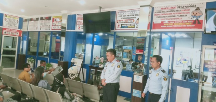 Foto: Muhammad Gani /Metro Asahan Kakanim TBA Panogu HD Sitanggang, didampingi Kasi Lalin Brema Sitepu menyapa pemohon paspor yang mengantri.
