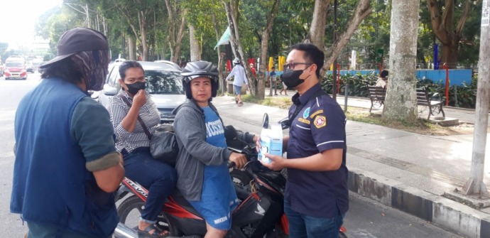 Pengurus Karang Taruna Kota Siantar membagikan masker kepada pengendara di Jalan Merdeka.