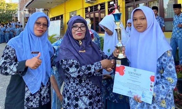 Foto: Kepala MAN 1 Padang Sidempuan Dra Hj Wasliah Lubis, MA menyerahkan piala dan sertifikat kepada anggota Paskibra berprestasi yang diraih.