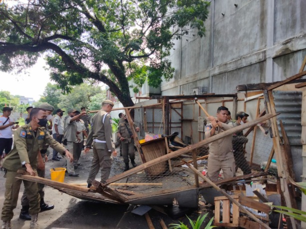 Petugas Satpol PP meratakan bangunan liar yang dibangun PKL di Jalan M Yamin Kisaran. (Perdana)