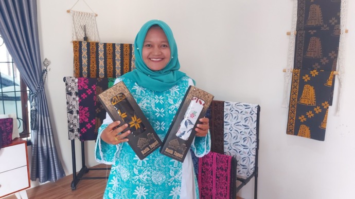 Foto: Dame Ambarita/Metro Tabagsel  Santi Budi Lestari, Ketua KUB Batik Tapsel & Bator Craft binaan PTAR, yang menggagas batik Tapsel, berfoto di depan kain-kain batik produksi KUB Batik Tapsel & Bator Craft, di di Kampung Pasir Kelurahan Aek Pining, Keca