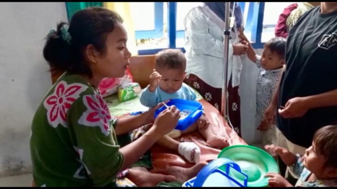 Foto: Orangtua salah satu anak diduga keracunan sedang menjaga anaknya di Puskesmas Mompang Julu, Kecamatan Panyabungan Utara.