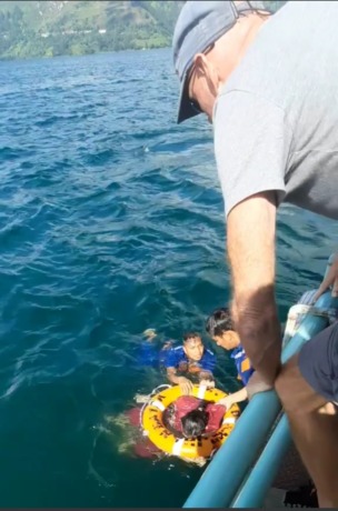 Petugas mengevakuasi perempuan penumpang kapal Feri Ihan Batak yang melompat ke Danau Toba, Kamis (2/2/2023).